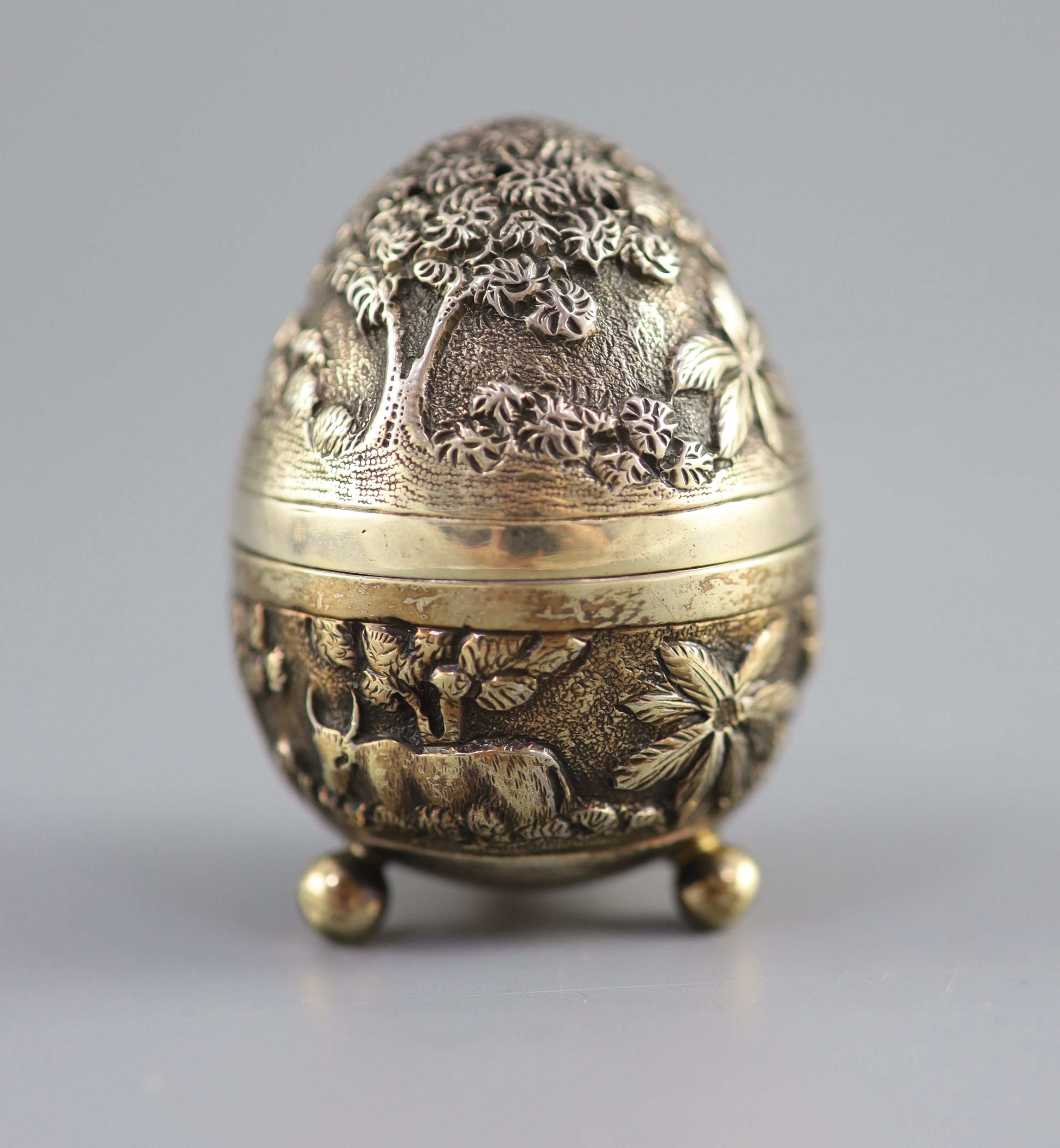 A graduated pair of Edwardian novelty silver gilt condiments, modelled as eggs, with bird's nest interior including two 'marbled' eggs